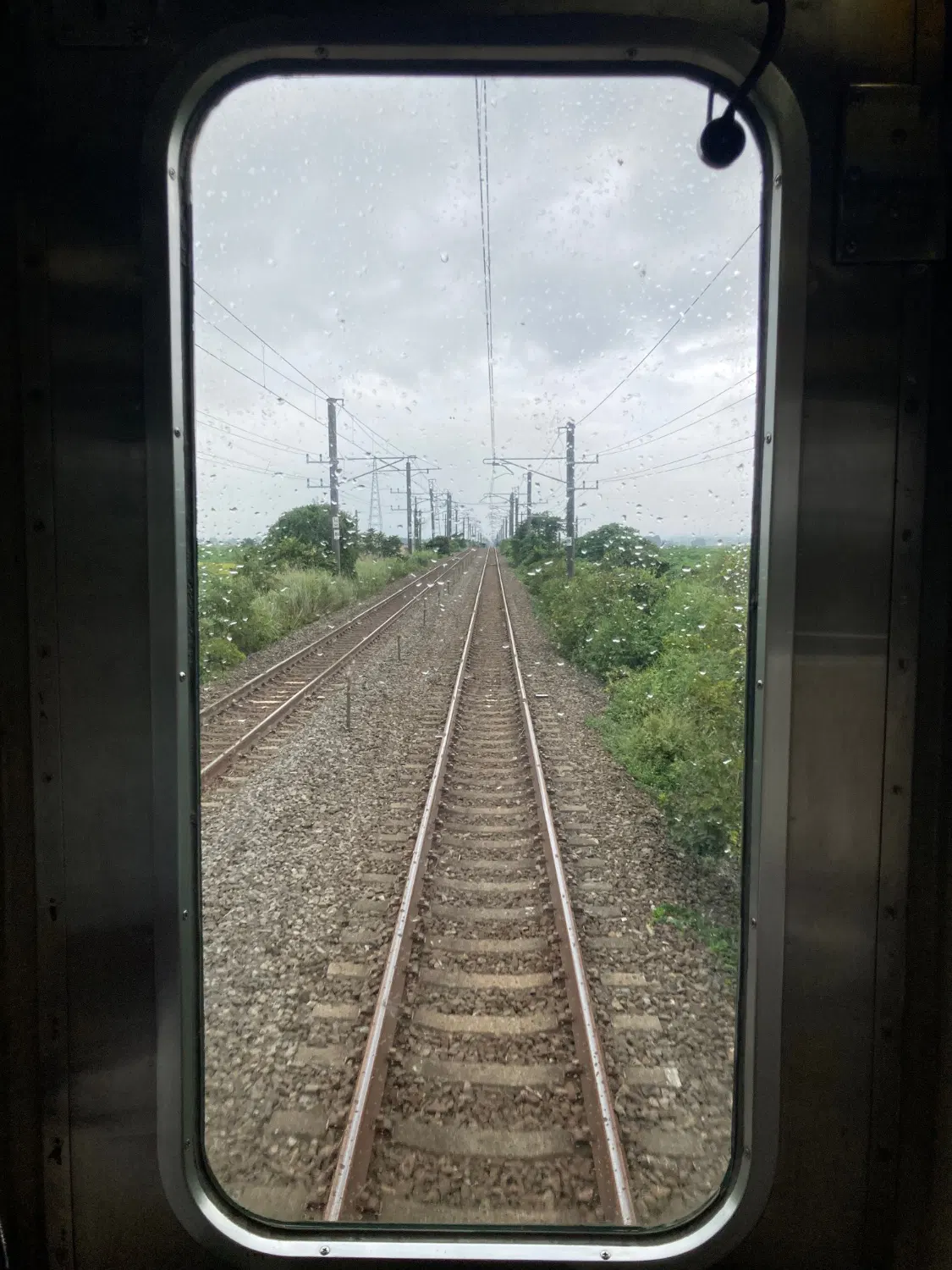 小牛田を過ぎたあたり、列車の後側から撮った写真、線路が真っ直ぐに伸びている