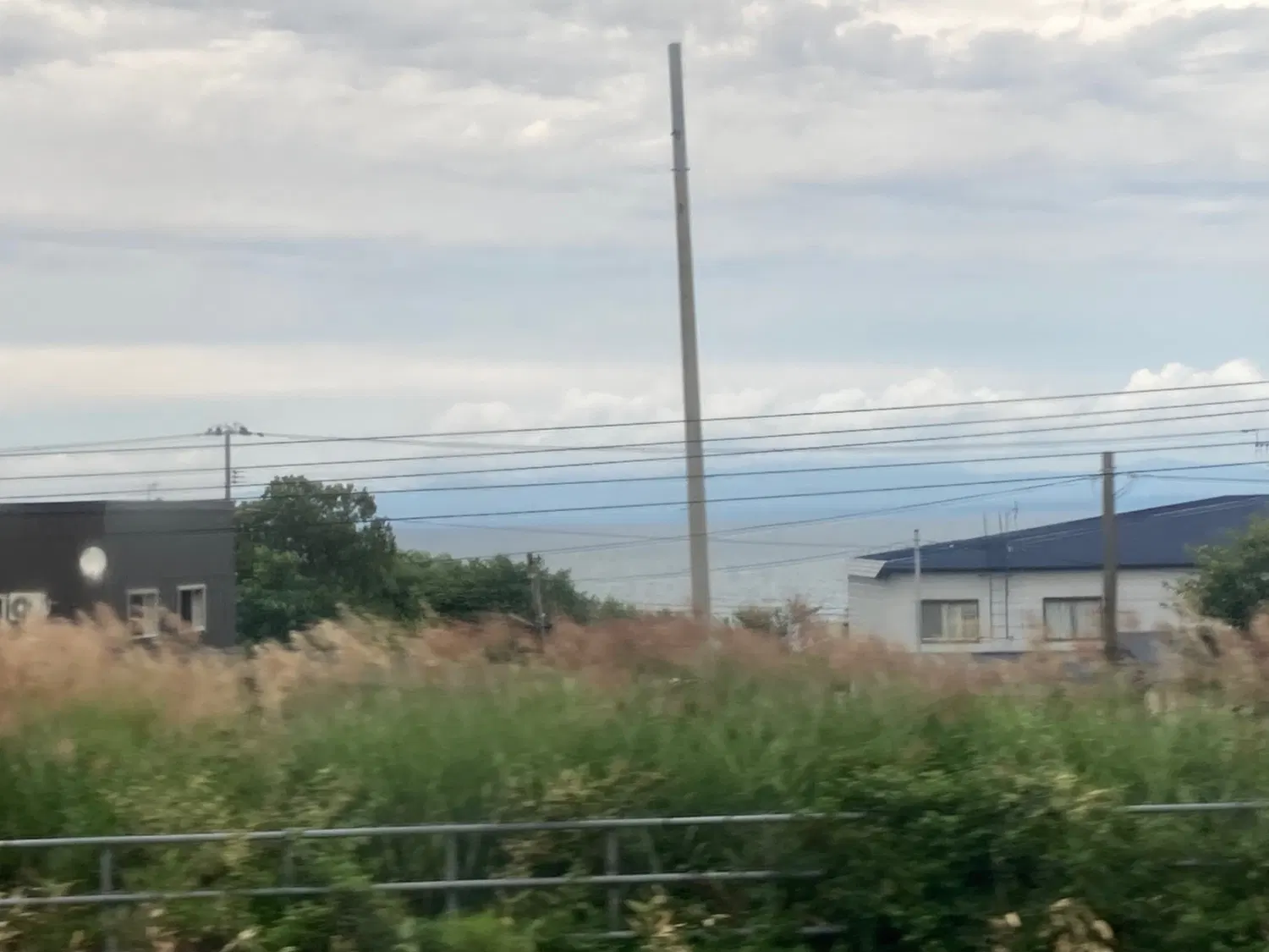車内から撮られた、家の間から海が写っている写真