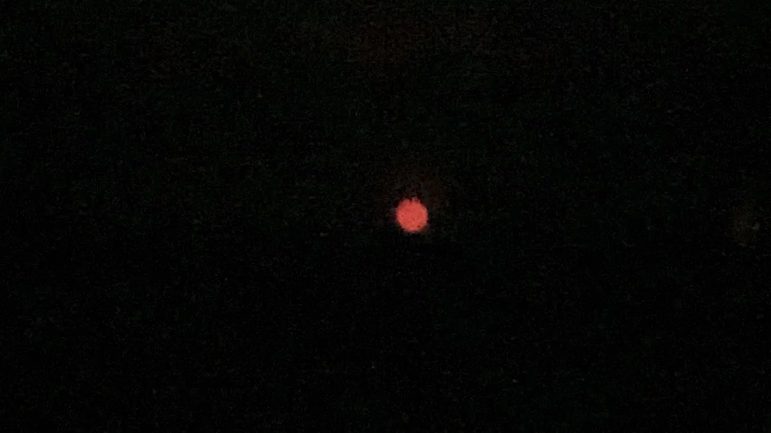 暗闇に映る赤い花火らしき光