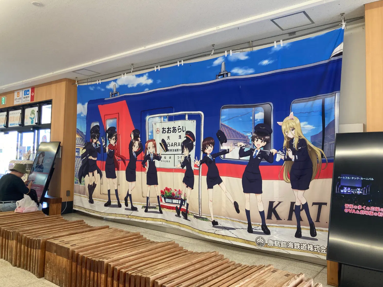 鹿島臨海鉄度の車両の前にガールズアンドパンツァーのキャラクターが立っている垂れ幕
